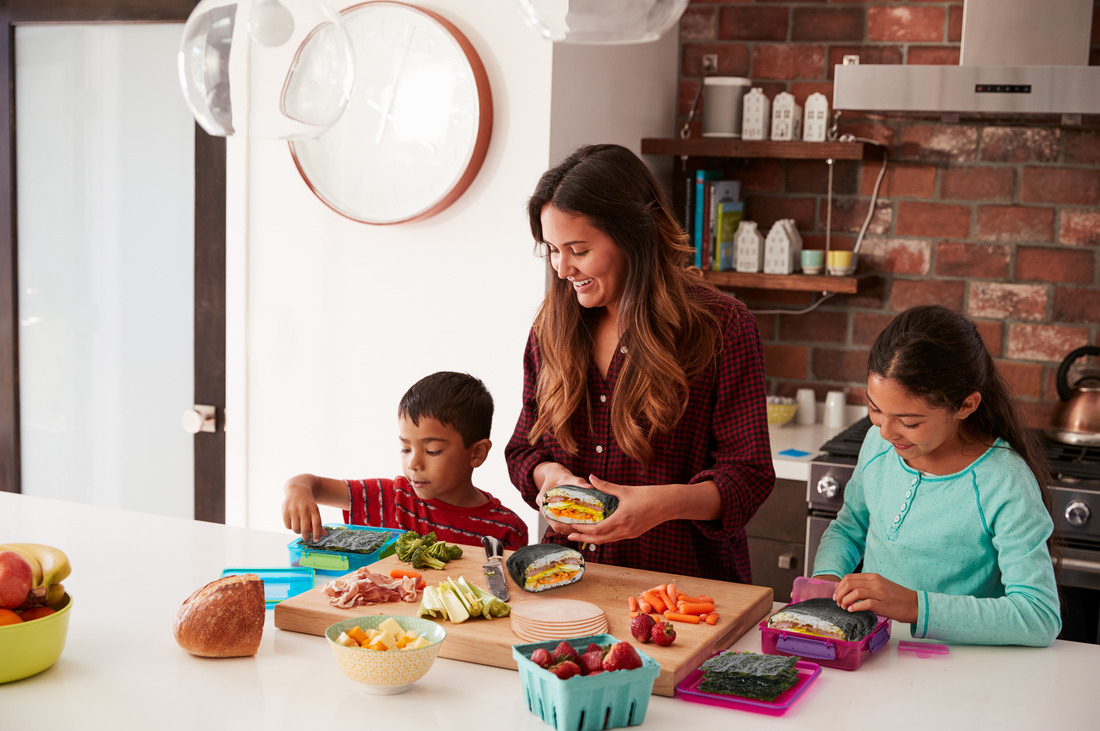 A mother and her two children making snacks with gimme seaweed.