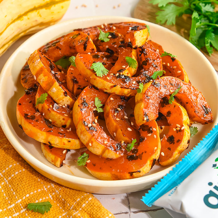 A bowl of air fryer gochujang squash sprinkled with Gimme seaweed snacks.