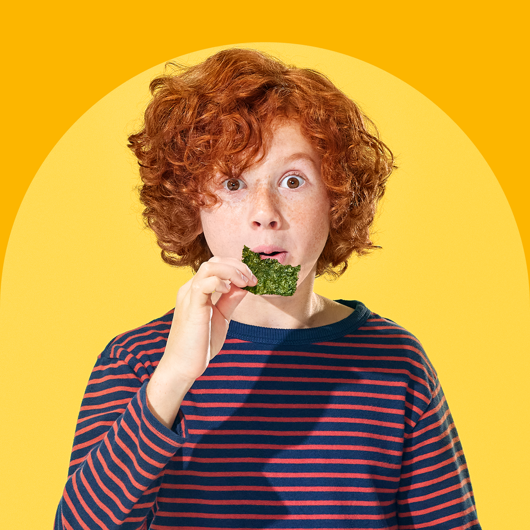 little boy eating gimme seaweed snack