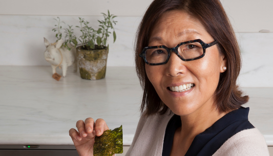 A woman holding a piece of seaweed.