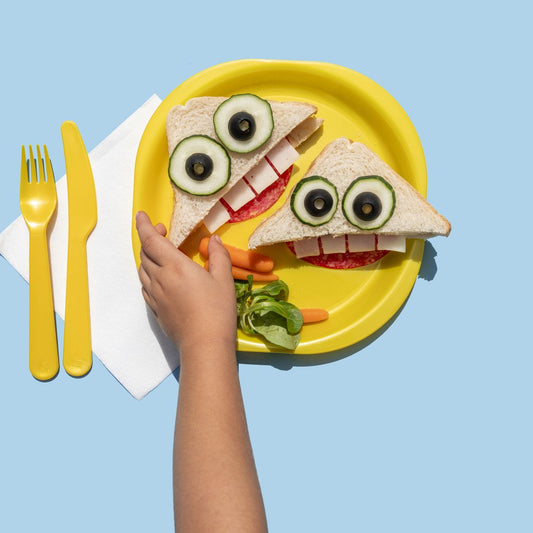 A plate with a sandwich with a face made with cucumbers.